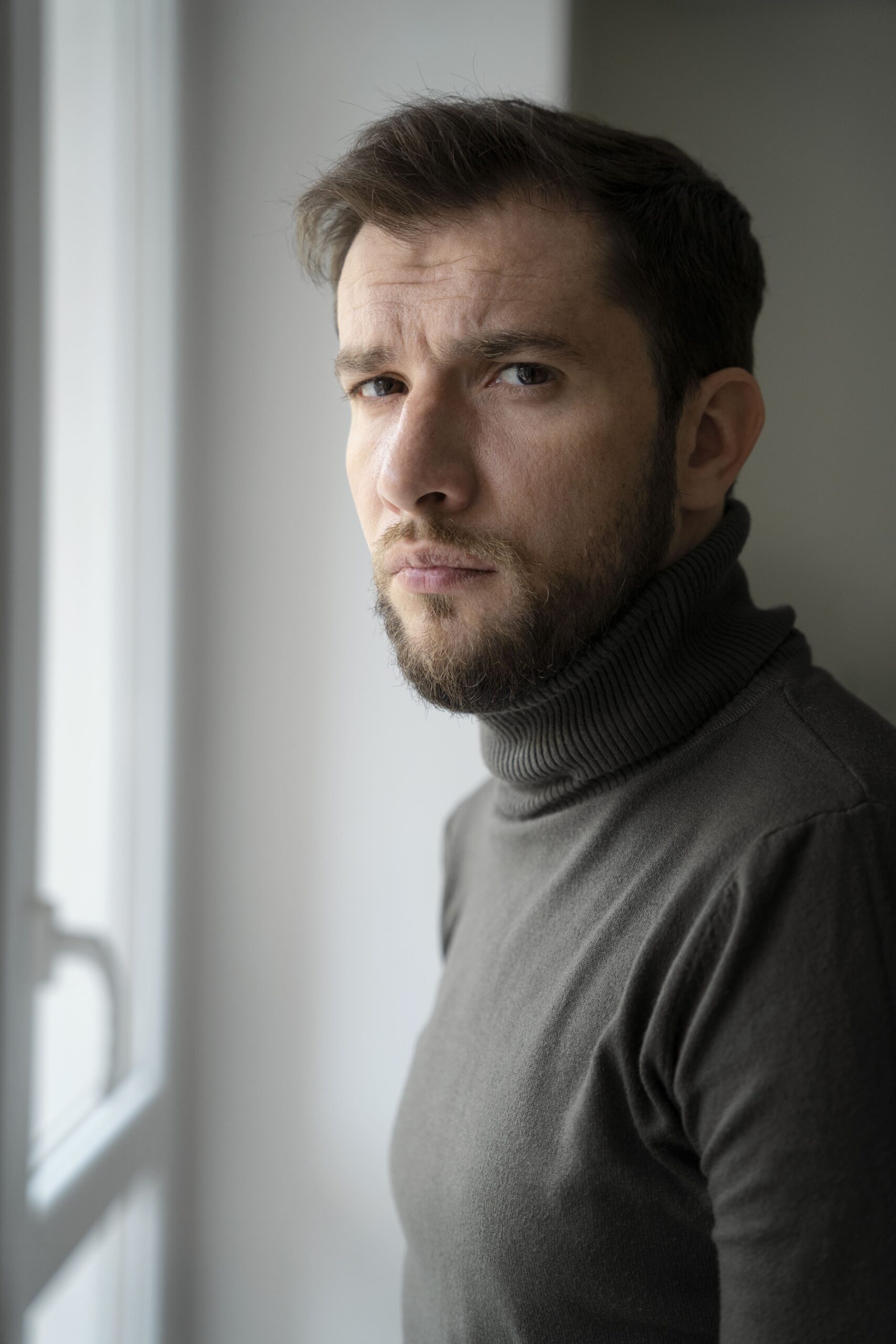 Hombre con suéter mirando serio al frente